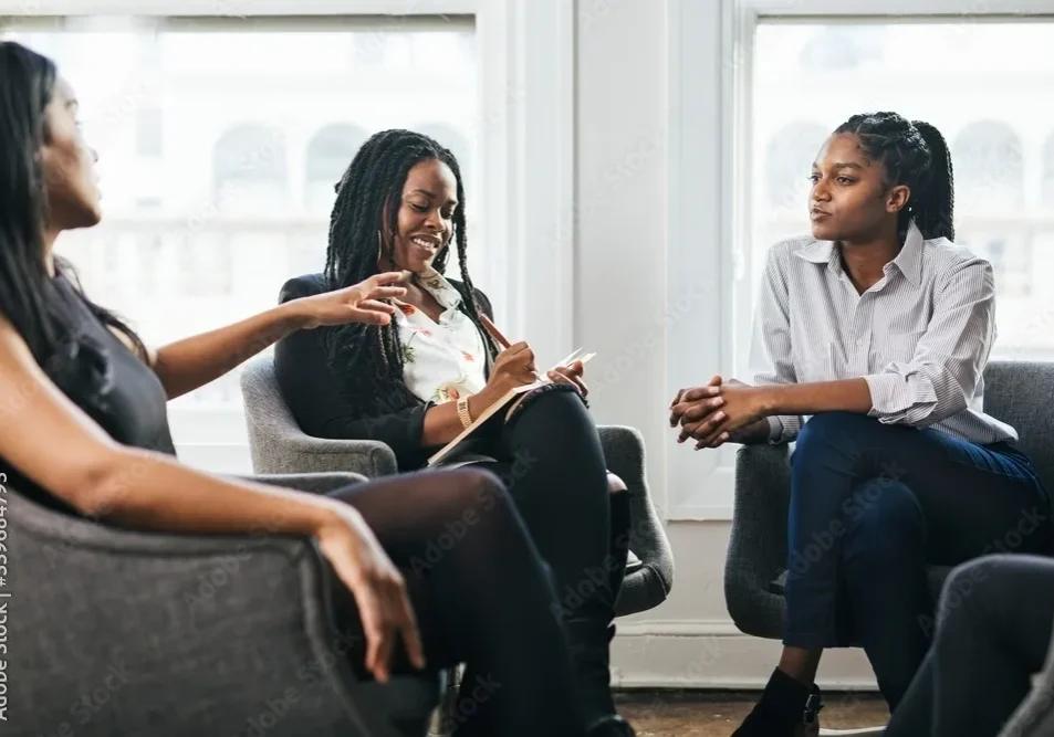 A group of people sitting around each other.